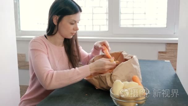 年轻的女人正在剥胡萝卜