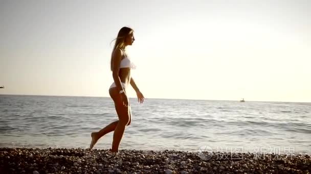 梦幻女郎漫步在鹅卵石海滩上视频