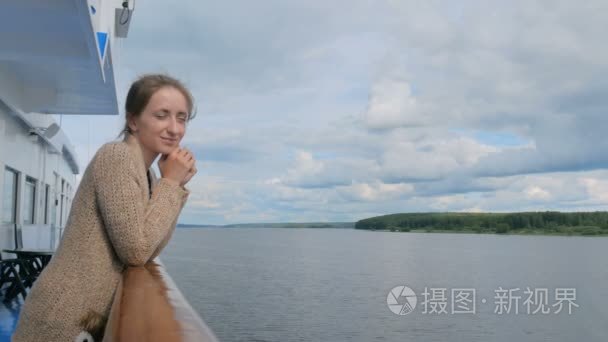 年轻女子站在邮轮甲板上, 看着河流和景观