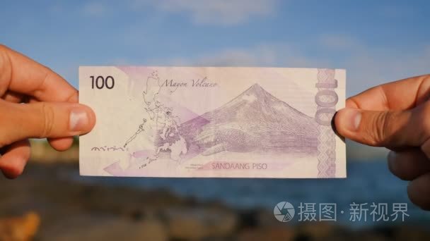 菲律宾的钱100比索的菲律宾货币纸币献给马荣火山火山