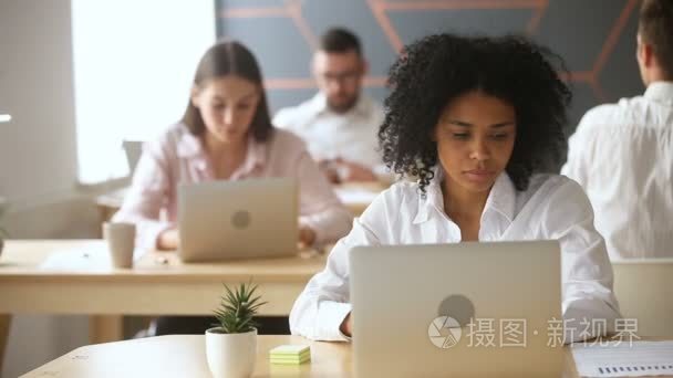 非洲裔美国女商人在 coworking 上使用图形的笔记本电脑