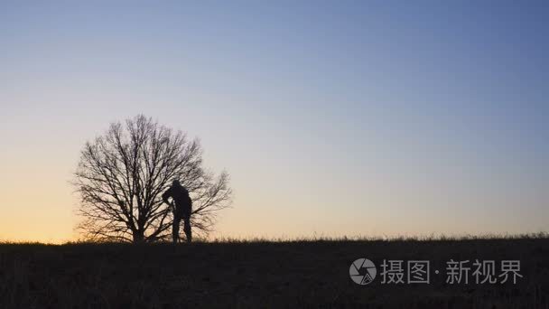 工人的剪影在晚上铲土用铁锹视频