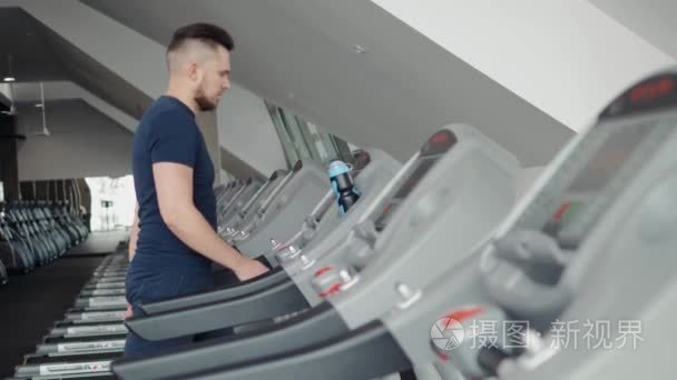 年轻男子在运动装跑步机在健身房  开始准备训练锻炼