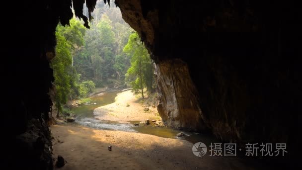 老妇人正在大洞穴的底部收集蝙蝠鸟粪  河水从肠子里流出。Tham Lod 洞穴泰国  排