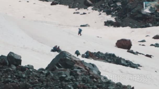 雪地车骑在雪山山坡上登山游客视频