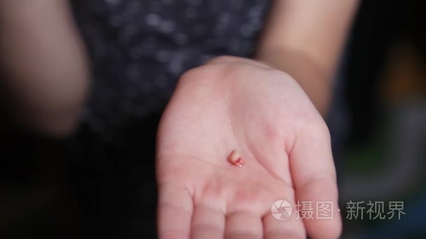从他手中的男孩撕裂的年轻牙齿.婴儿手里拿着一颗牙.