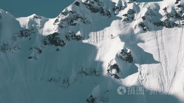 滑雪者的长的射击从山顶的极端雪覆盖的山顶跳跃