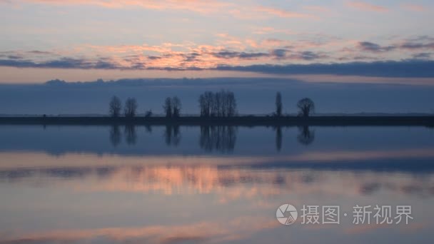 一只鸟儿在日出时飞过水面视频