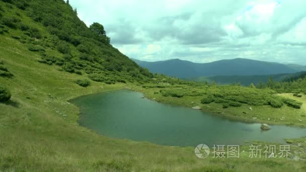 在山坡和山峰的背景下清洁湖泊视频