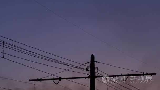 高压电塔  从工厂黑烟和足迹从飞机在傍晚的天空。4k