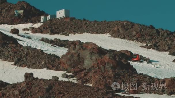 雪地修剪机骑在山顶覆盖的积雪视频