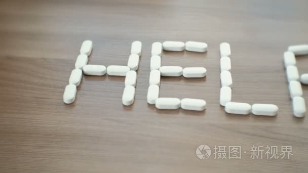 文字帮助由桌上的药片组成视频