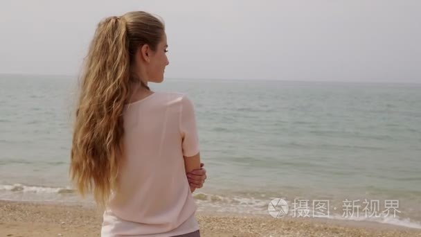 金发女郎从海滩上望向大海