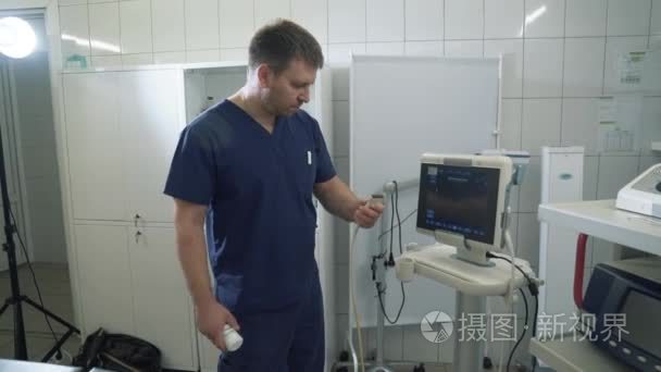 医院的外科医生对超声波机上的器官进行研究。医生在医院或诊所展示医疗工具