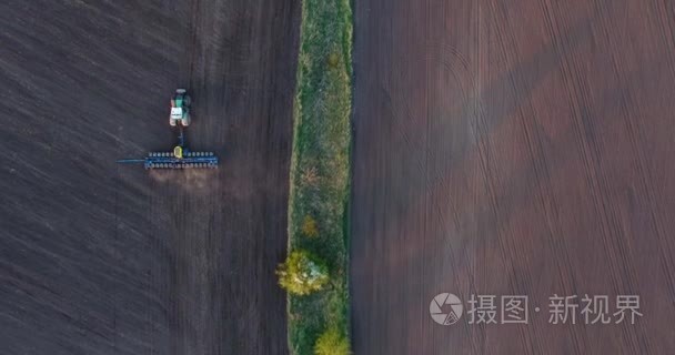 日落时拖拉机种植小麦的顶部视图