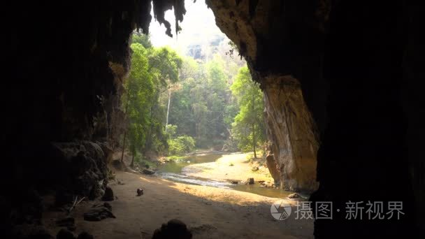 老妇人正在大洞穴的底部收集蝙蝠鸟粪, 河水从肠子里流出。Lod 洞穴泰国, 排