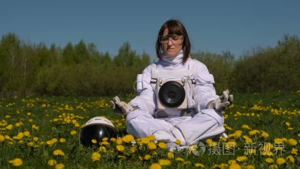 女孩宇航员在花卉领域练习冥想视频