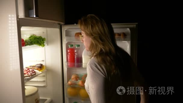 女人晚上打开冰箱。夜饥饿。饮食。暴食, 4k