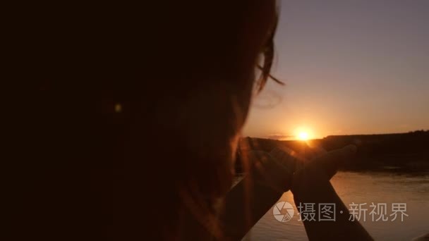 女孩在日落时抱着红色的太阳视频