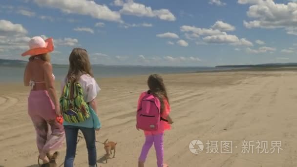 妈妈带着两个女儿沿着海滩散步视频