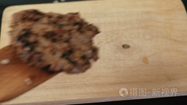 用木铲把肉饼放在木木板上视频