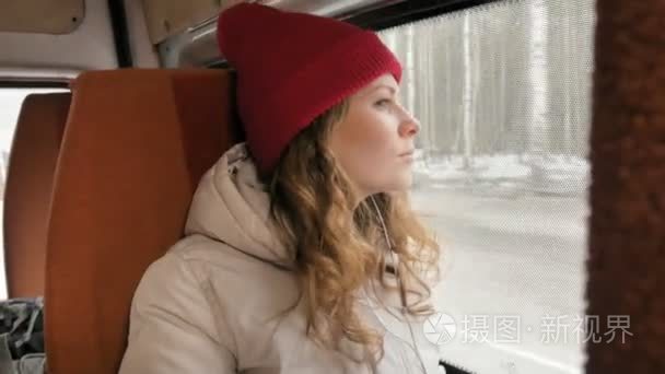 年轻快乐的女人乘公交车在悲伤的一天旅行.她向窗外望去短视频