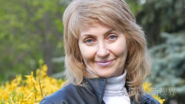 妇女的肖像, 在多年的白色头发和蓝色的眼睛看着相机, 轻轻地微笑温柔