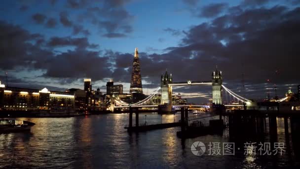 黄昏的夕阳五彩缤纷的云彩在伦敦的塔桥和碎片的城市灯