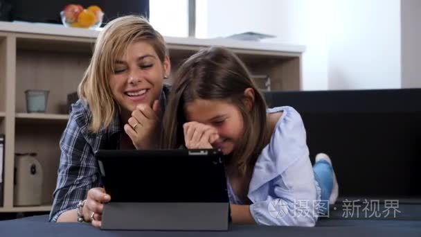 妇女和她的女儿通过视频电话与某人交谈与平板电脑