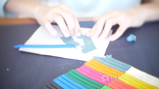 坐在桌边的女孩从颜色模型橡皮泥画出不同的数字。儿童艺术造型的发展。4k特写视频