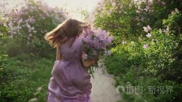 女孩带着一束丁香花奔跑着。