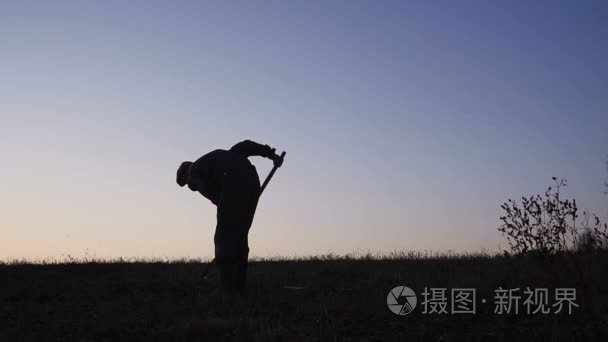 工人的剪影在晚上铲土用铁锹视频