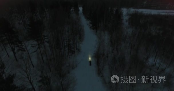 雪地车在夜间骑在树林里视频