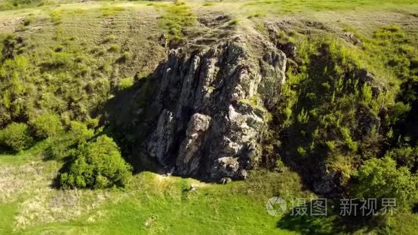 在风景如画的山谷  绿色的田野和丘陵  岩石峭壁和山脉  岩石日志和河流上空拍摄的空中镜头。春天和夏天季节自然概念的周末