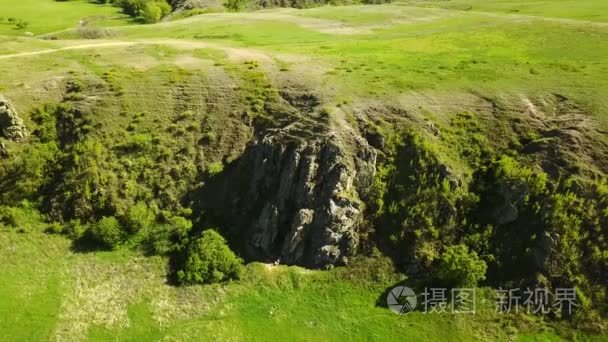 在风景如画的山谷, 绿色的田野和丘陵, 岩石峭壁和山脉, 岩石日志和河流上空拍摄的空中镜头。春天和夏天季节自然概念的周末