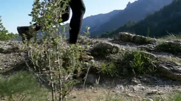 在山上的悬崖顶上行走的旅行女子徒步旅行。慢动作