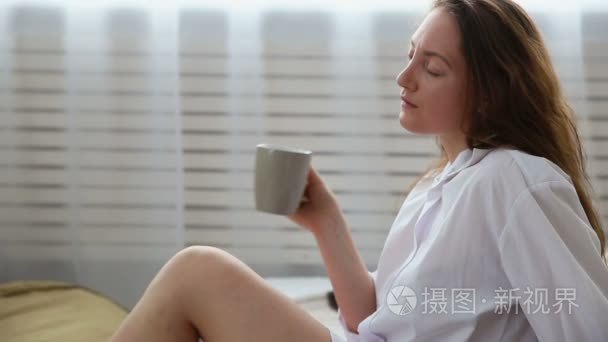 穿白衣的女人在床上喝咖啡视频