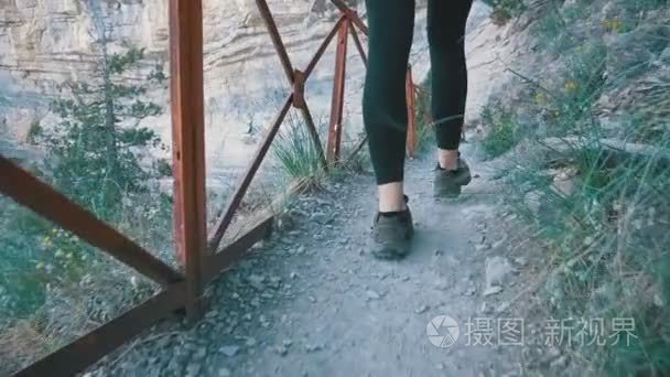 在石山小径上行走的旅行女子徒步旅行的观点。慢动作视频