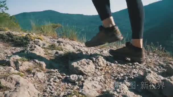 在山上的悬崖顶上行走的旅行女子徒步旅行。漫步在岩石上