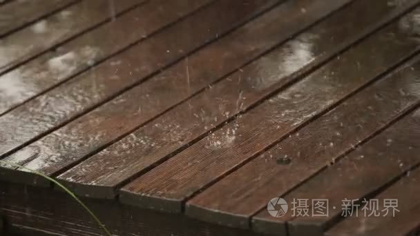 雨点落在木地板的户外凉亭上视频