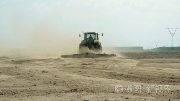 一台农业机械的拖拉机处理土壤  大量的灰尘上升
