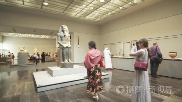 人们看在阿布扎比的新卢浮宫博物馆展出的展品录像视频