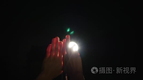 人类男性手,举起手指在聚光灯下或背光灯在黑色的背