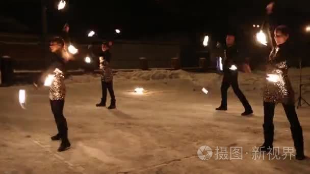 令人惊叹的部落火灾表演在冬天的雪下, 在夜晚跳舞。舞蹈团在下雪的天气里表演火炬灯和烟火