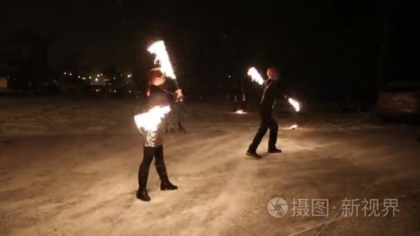 令人惊叹的部落火灾表演在冬天的雪下, 在夜晚跳舞。舞蹈团在下雪的天气里表演火炬灯和烟火