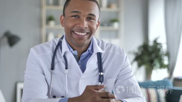 微笑积极的非洲裔美国医生在工作看相机