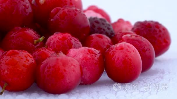 关闭在白色背景上隔离的 lingonberries 堆。在转盘上旋转。水滴