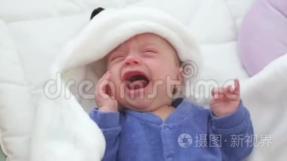 新生儿哭婴儿。 新出生的孩子又累又饿，躺在蓝色针织毛毯下。