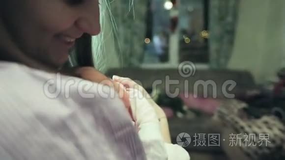 幸福的母亲抱着一个新生婴儿在房间里。