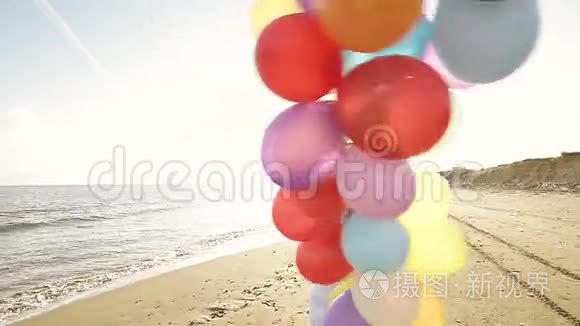可爱的女孩在海滩上玩气球视频